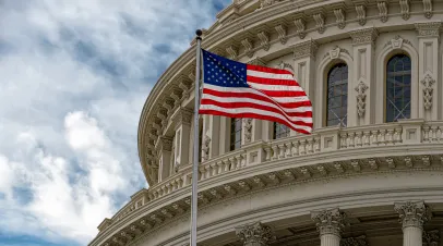 Washington DC Capitol with waving flag on cloudy day