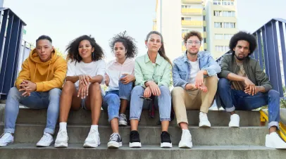 Youth sitting along sidewalk