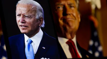 In focus image of President Joe Biden speaking with out of focus shot of Trump behind him