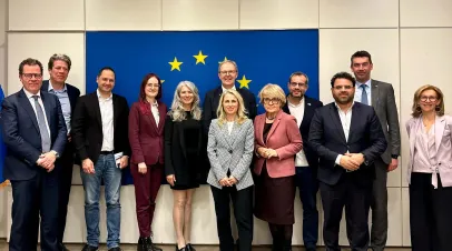 Group of people standing before a EU flag