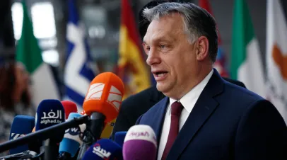 Victor Orban standing and speaking into television cameras