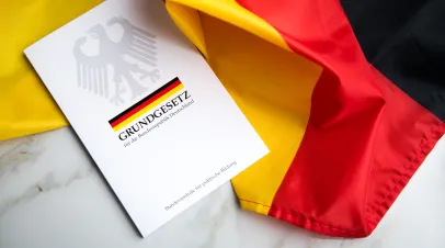 A copy of the German Constitution's basic law sitting on the flag of Germany