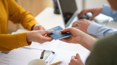 Woman handing another person a Ukrainian passport 