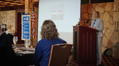 GMF President Heather A. Conley speaks at a podium in front of a screen that reads "Whistlestops for Ukraine"