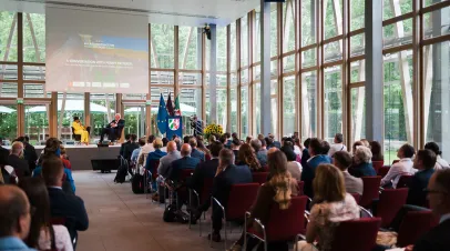 People sitting in chairs looking at a stage with two people sitting on it and speaking