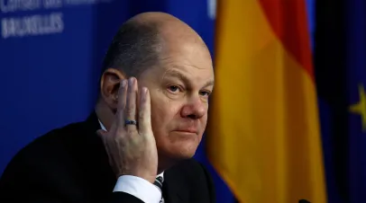 German Chancellor Olaf Scholtz sitting with his hand resting on his face