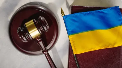 Gavel sitting on a table next to a small Ukrainian flag 