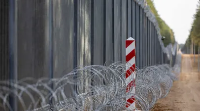 Image of fence at Polish Belarus border, with barbed wire