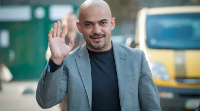 Ukrainian official Mustafa Nayyem, a bald man with a sport coat, waving to the camera