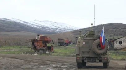 A military vehicle with a Russian flag attached to its rear