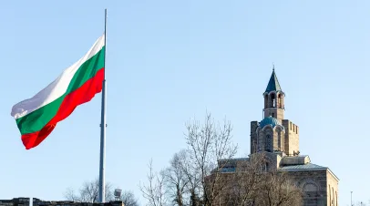 Bulgarian flag flying with a church in the background