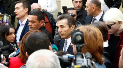 Georgian oligarch Bidzina Ivanishvili surrounded by a crowd of journalists 