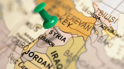 Map of middle east with a push pin inserted into the Syria part of the map