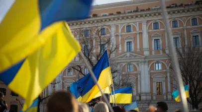 A crowd in Italy carrying Ukrainian flags