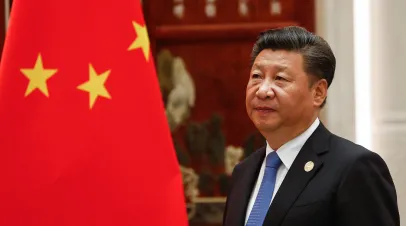 Chinese President Xi standing next to a Chinese flag