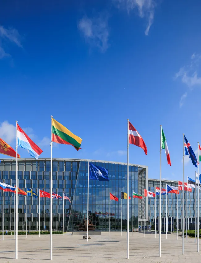 NATO logo flags in front of the headquarters building in Brussels, Belgium.