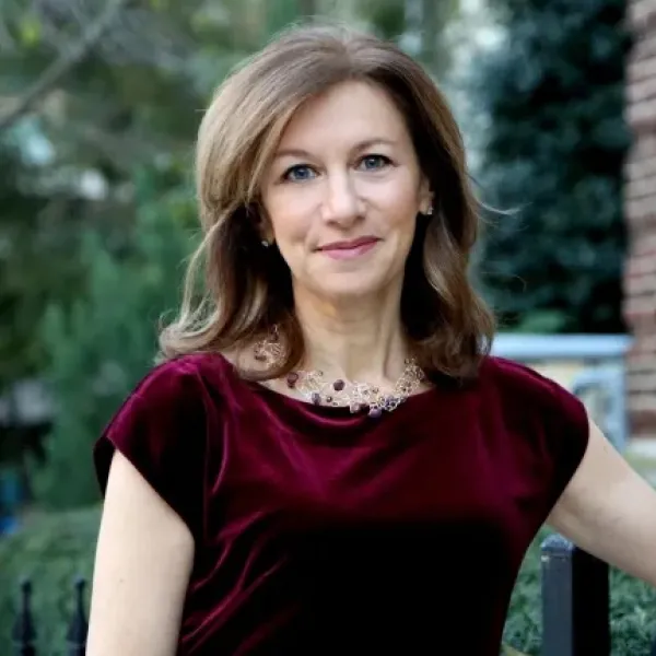 Middle aged woman wearing a maroon dress 